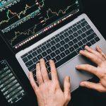 un sujeto revisando su computadora viendo la bolsa caer sin entrar en panico