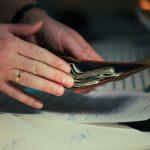 a man checking his wallet counting dollars having read 5 Financial Goals for 2026